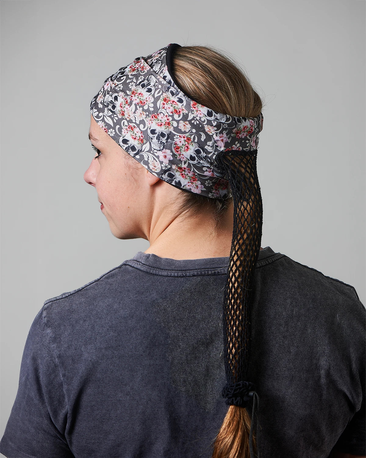 Gray Floral Mystical Skulls wide headband with ponytail protector, back view on female model.