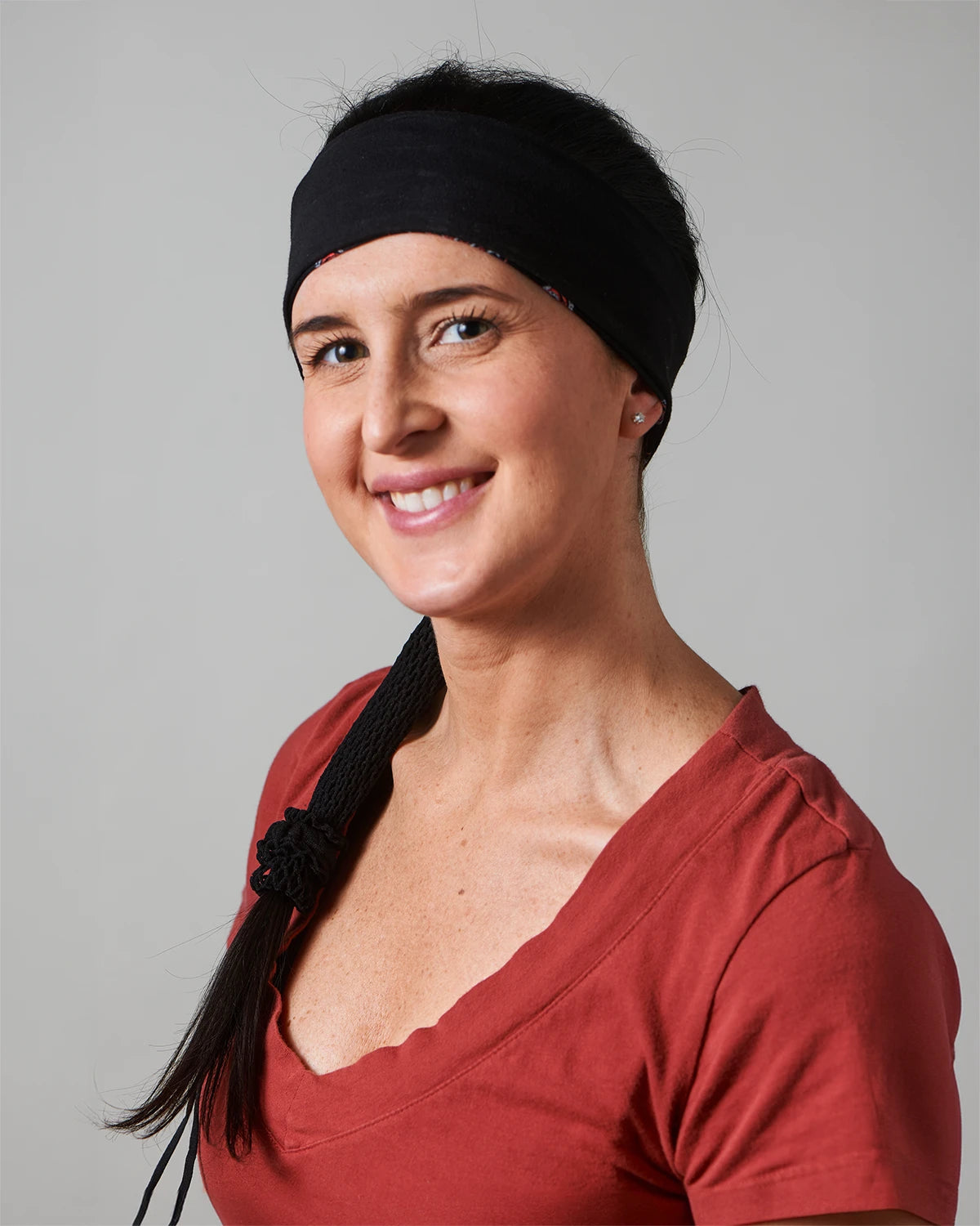 Black Skulls headband with ponytail protector, reverse front view on female model.
