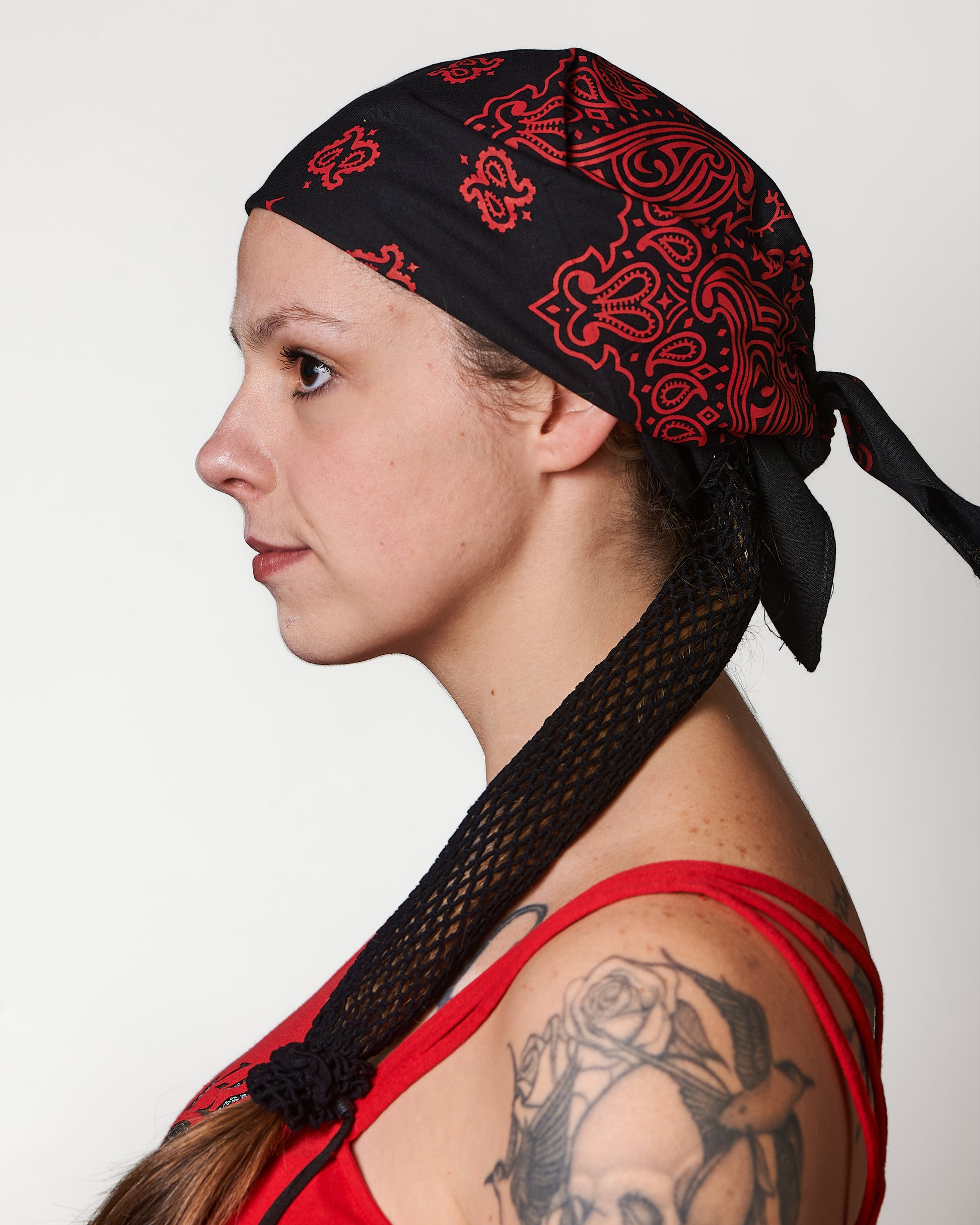 Extra Thin Black Headband, shown under black and red bandana (not included), side view, Female model.