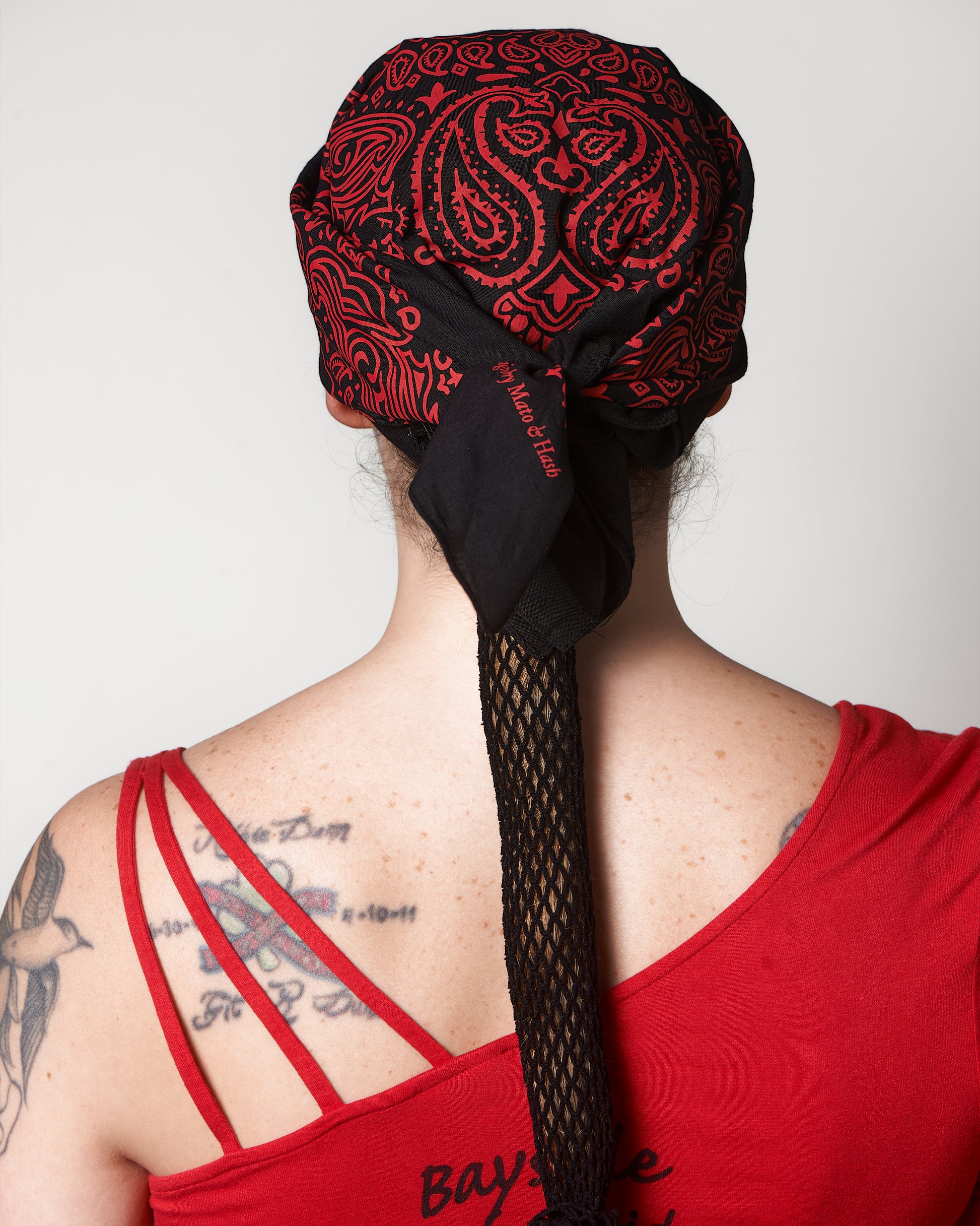 Extra Thin Black Headband, shown under black and red bandana (not included), back view, Female model.