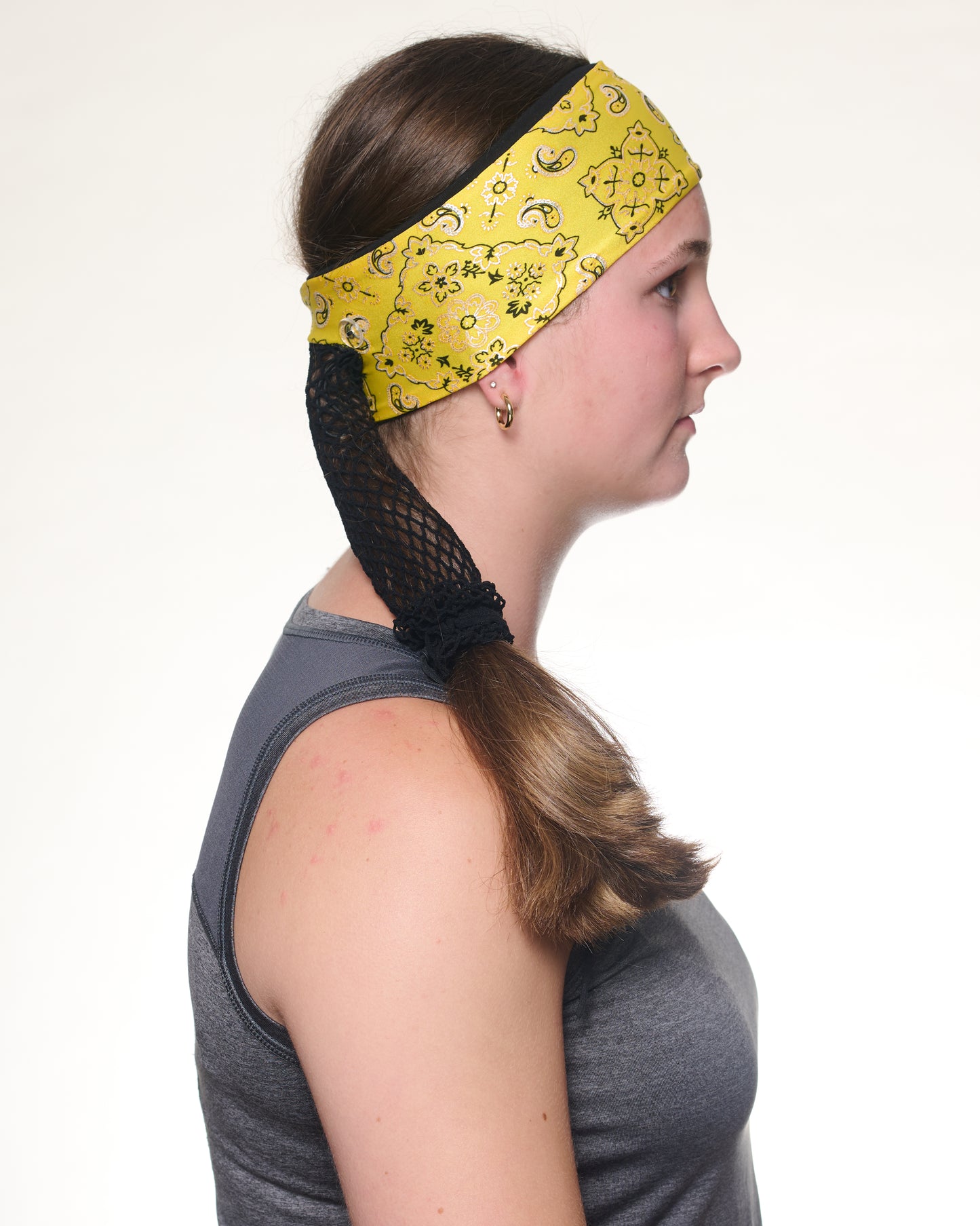 Yellow Brilliance Bandana headband with ponytail protector, side view on female model.