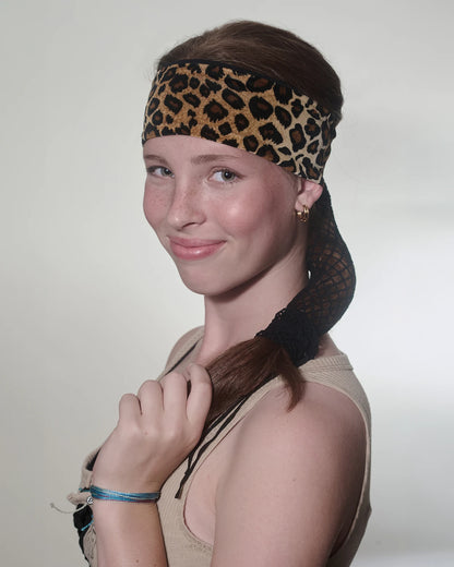 Cheetah print headband with ponytail protector, front/side view on female model.