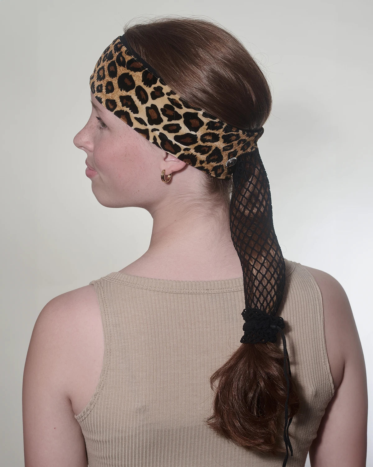 Cheetah print headband with ponytail protector, back/side view on female model.