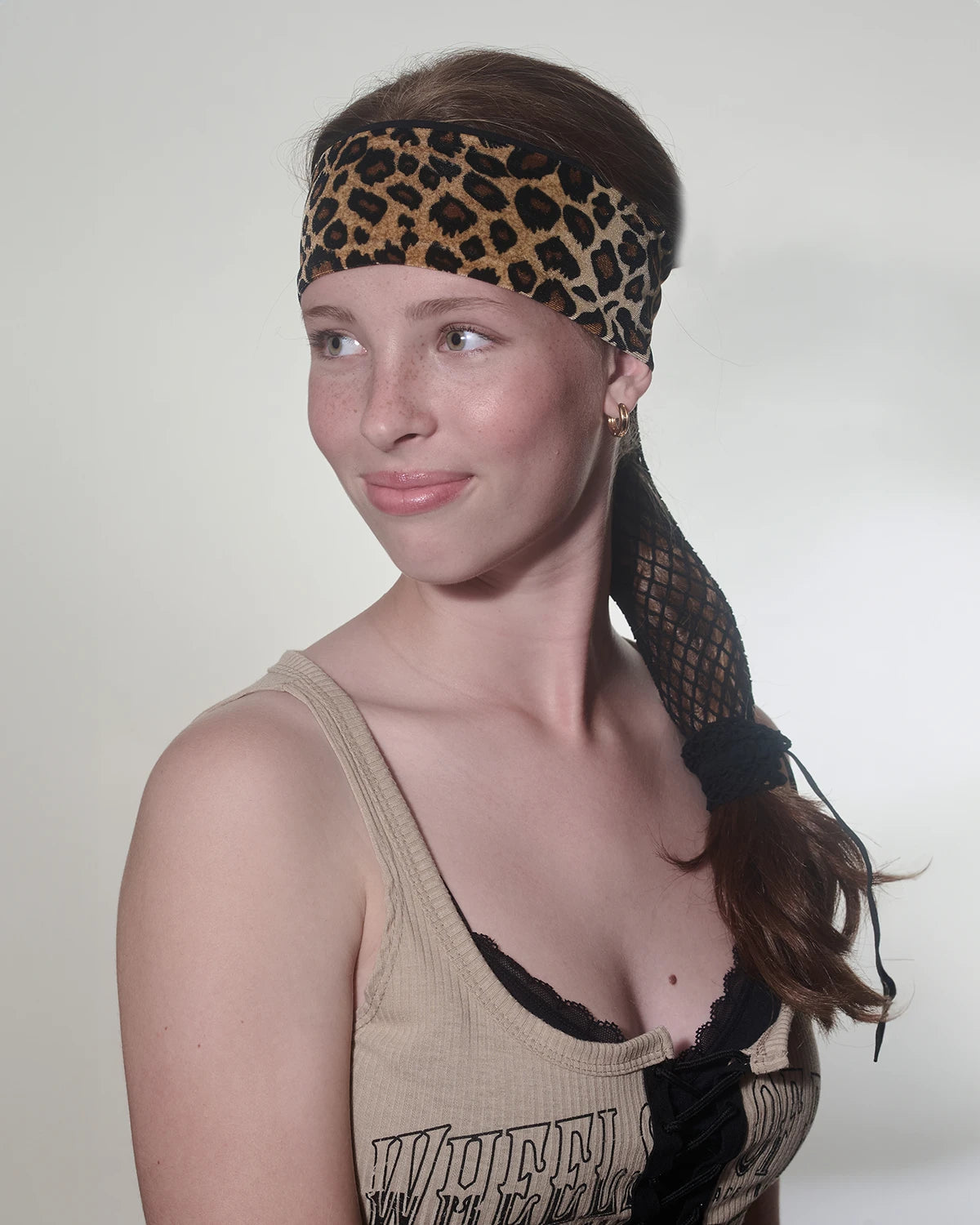 Cheetah print headband with ponytail protector, front view on female model.